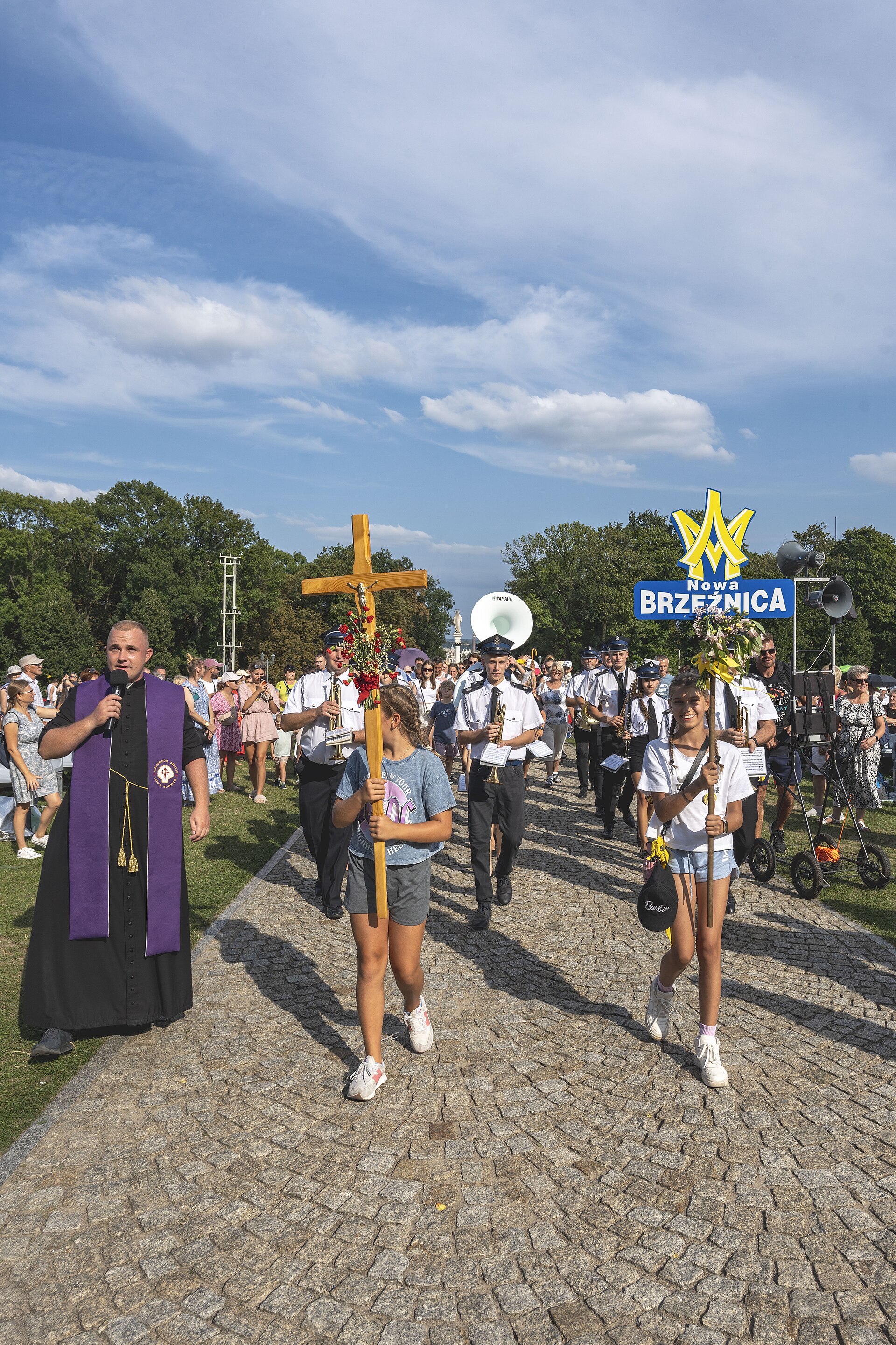 Piesza pielgrzymka wchodząca na błonia jasnogórskie z krzyżem i orkiestrą